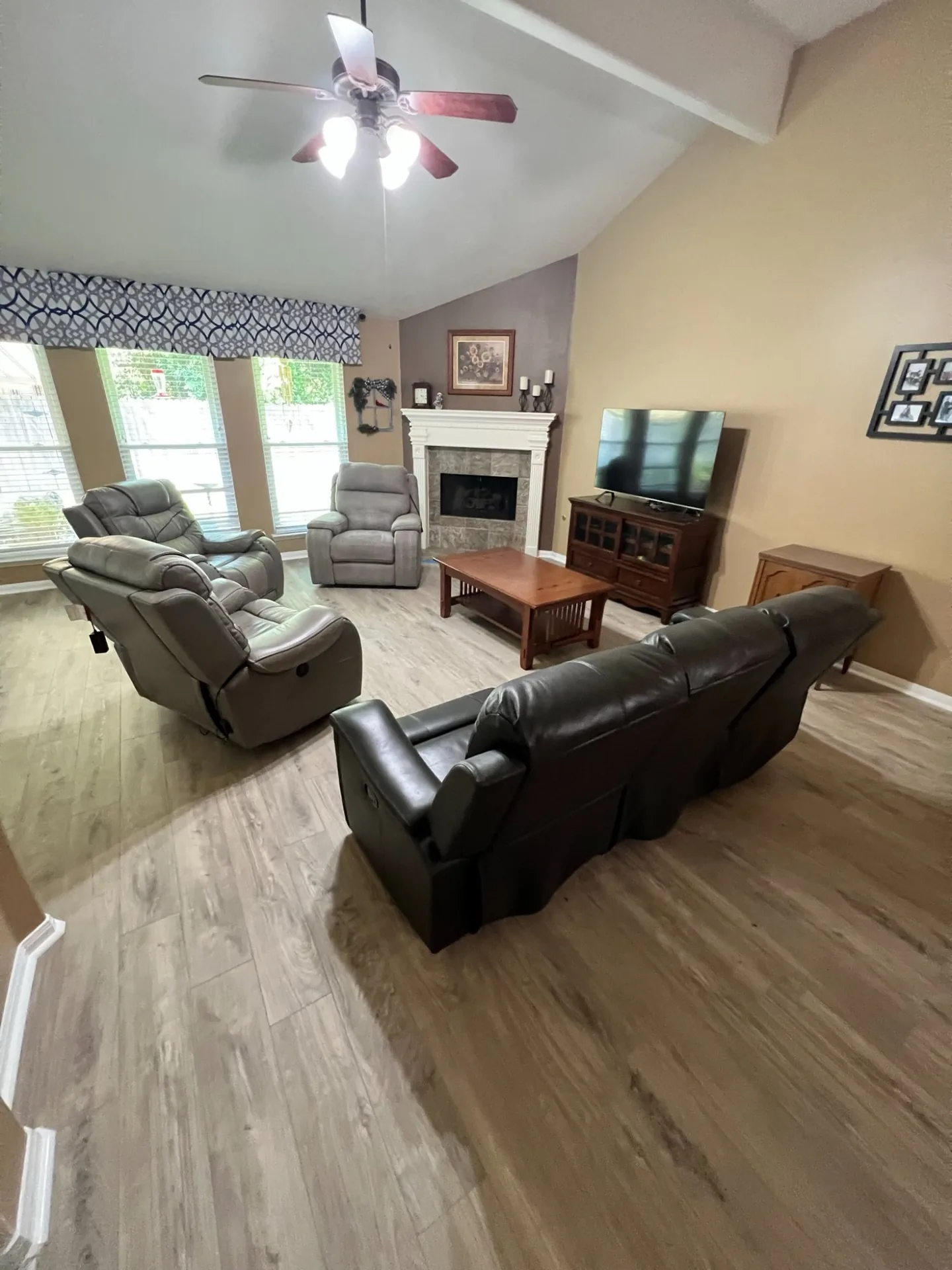 Classic gray vinyl plank across a furnished living room with a fireplace and recliners