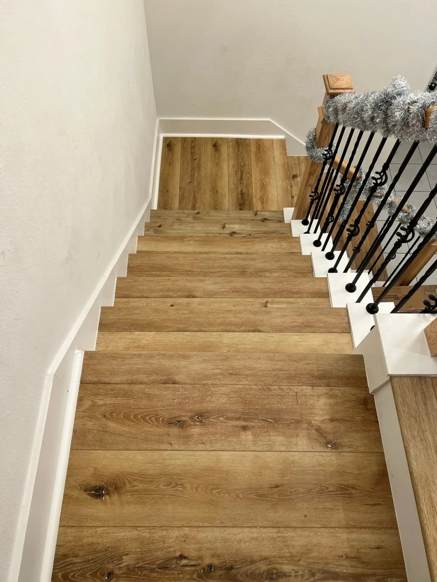 A staircase in rustic oak vinyl plank looking down from the landing